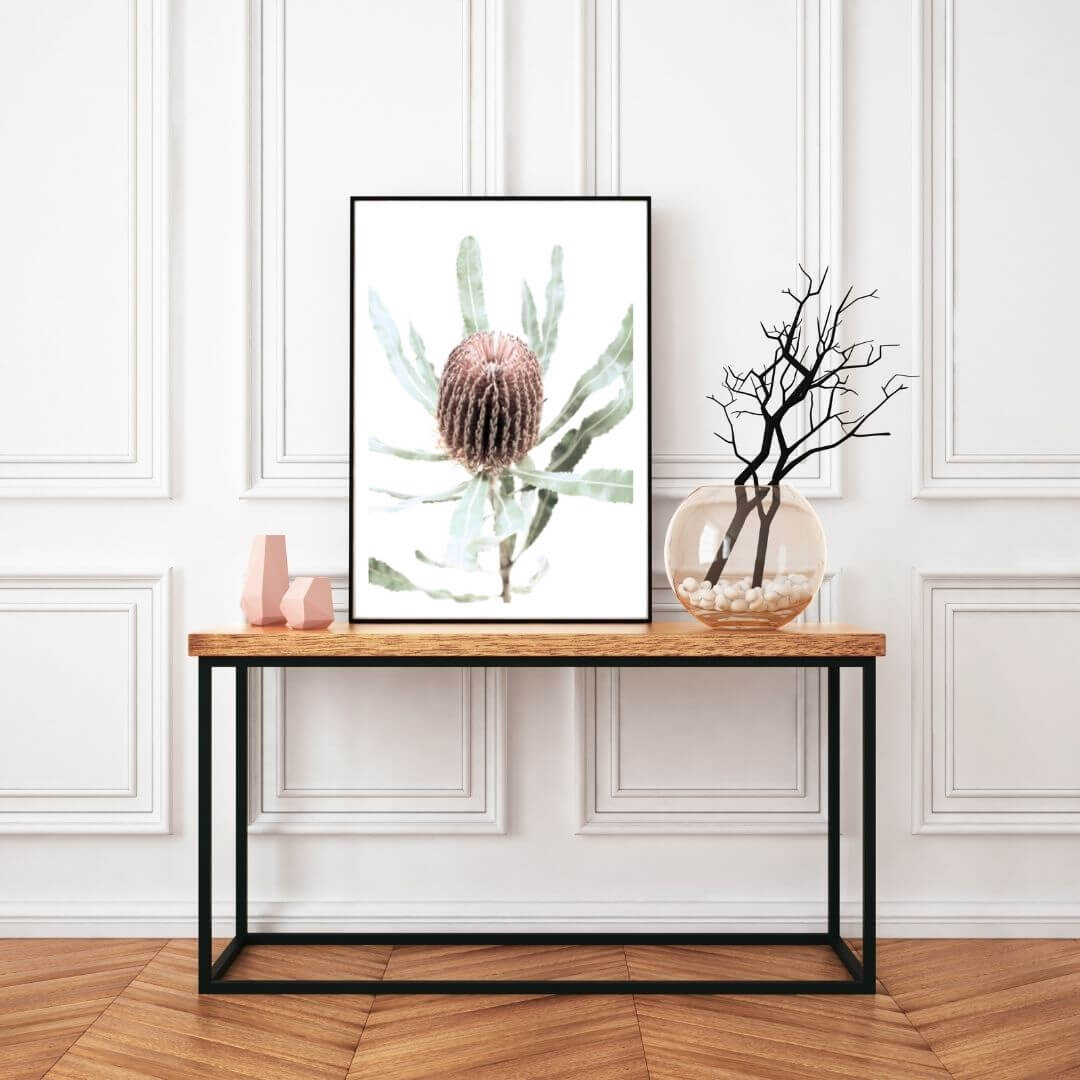 The wall art print of an Australian Native Banksia  Flower B with a frame in black or unframed in the hallway on a table