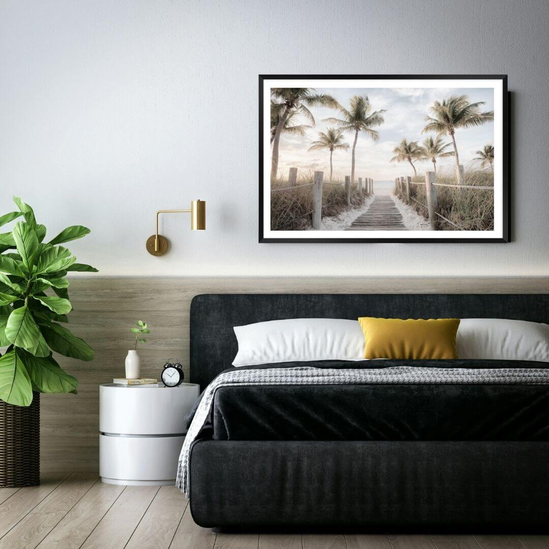 A wall art photo print of a pathway to a beach on the keys florida with palm trees with a frame in black to style a wall in bedroom