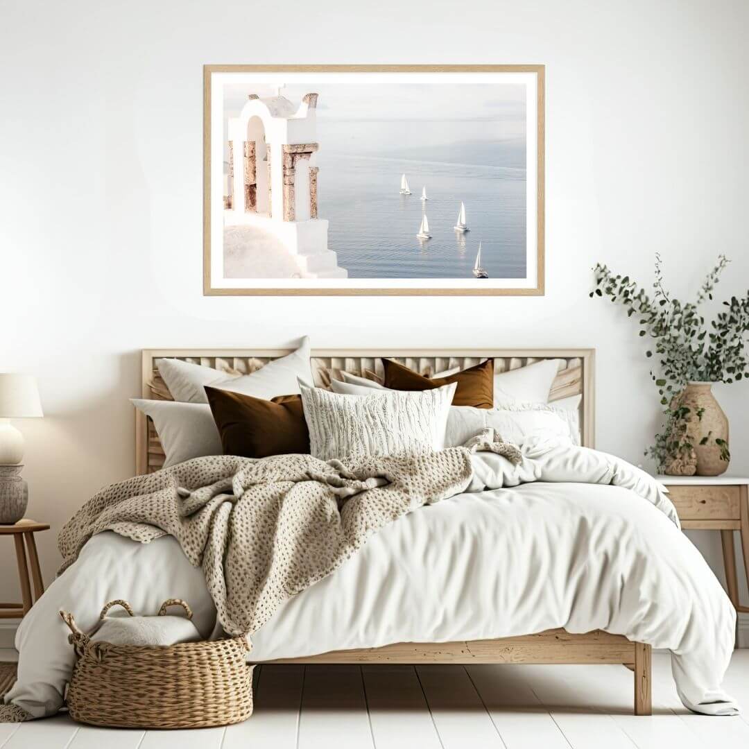 A coastal wall art photo print of Boats sailing on the sea in Santorini Greece  with a timber frame to style a coastal Australian bedroom