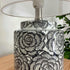 The gorgeous Camelia Table Lamp has a black and white ceramic base with a floral design and white fabric shade, 