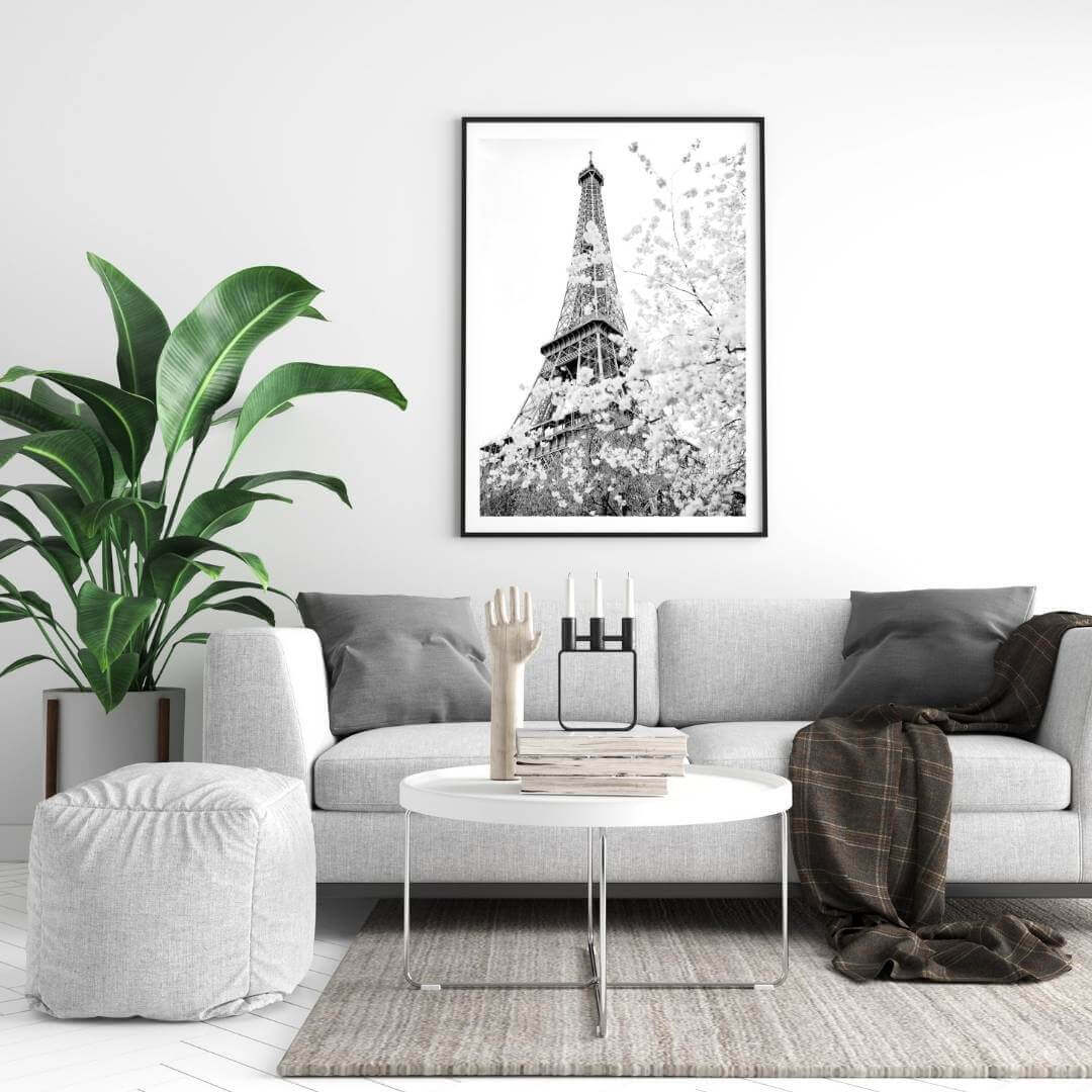A black and white wall art photo print of the Eiffel Tower in Spring with a black frame on a wall above a sofa by Beautiful HomeDecor