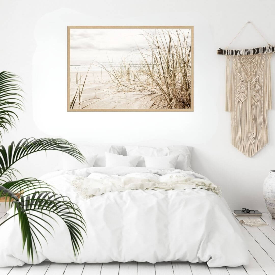 A wall art photo print of a grassy beach shore with a timber frame to style a coastal Australian bedroom