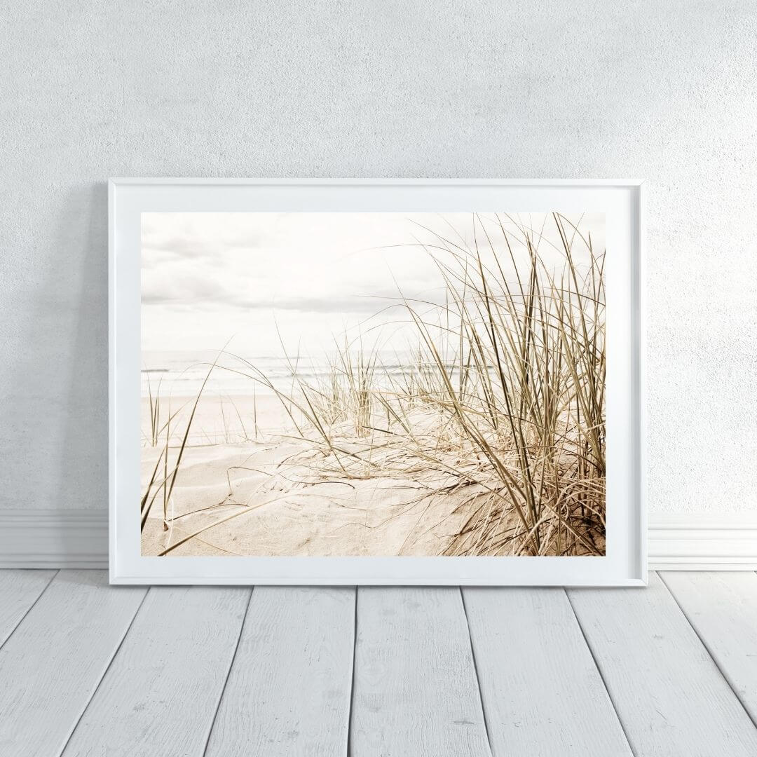 A wall art photo print of a grassy beach shore with a white frame or unframed to decorate an empty wall