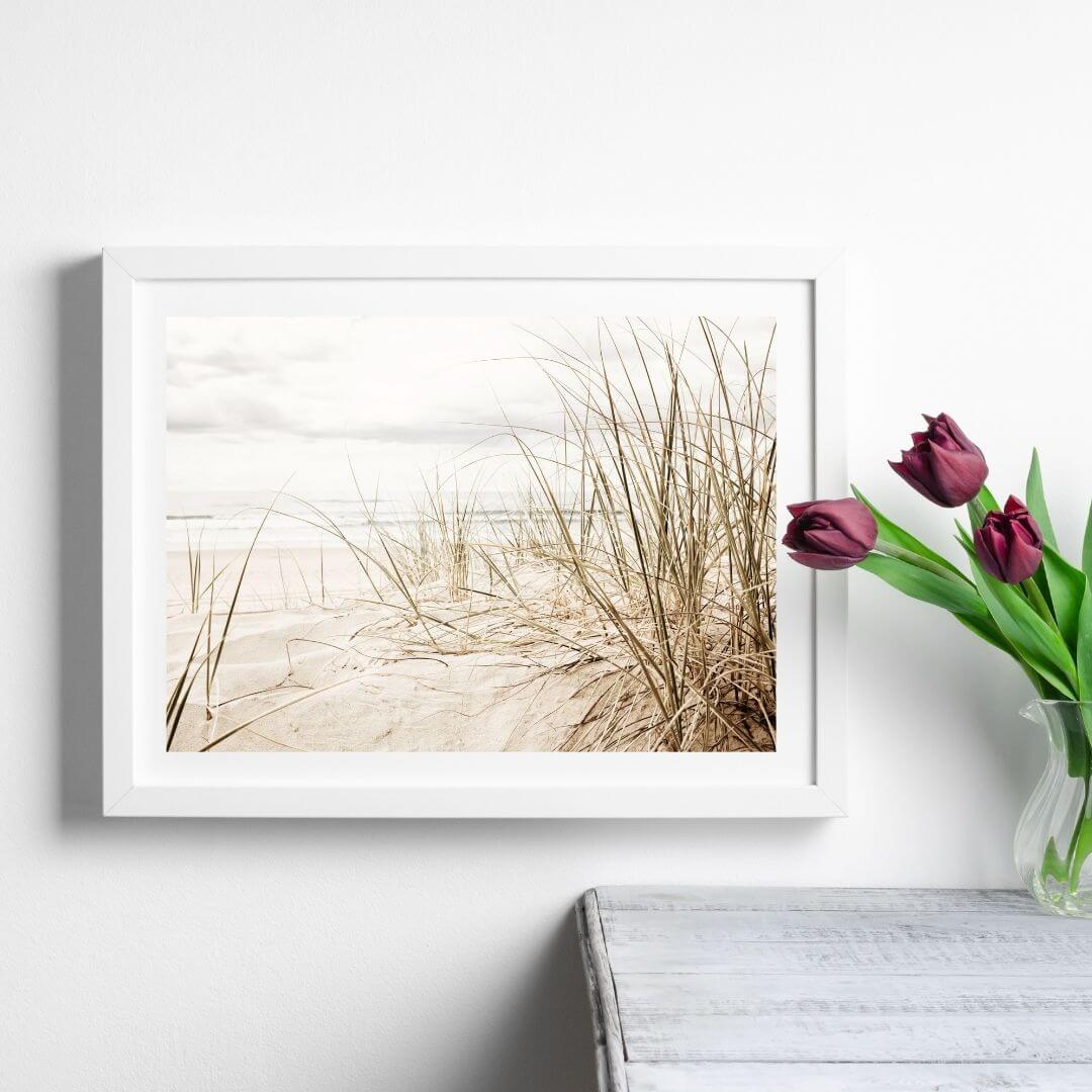 A wall art photo print of a grassy beach shore with a white frame or unframed to style shelves and empty walls