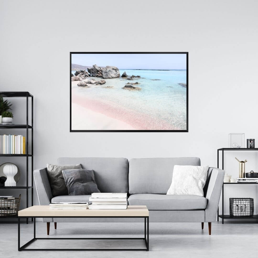 A wall art photo print of a pink beach in Greece with a black frame on a wall above a sofa by Beautiful HomeDecor