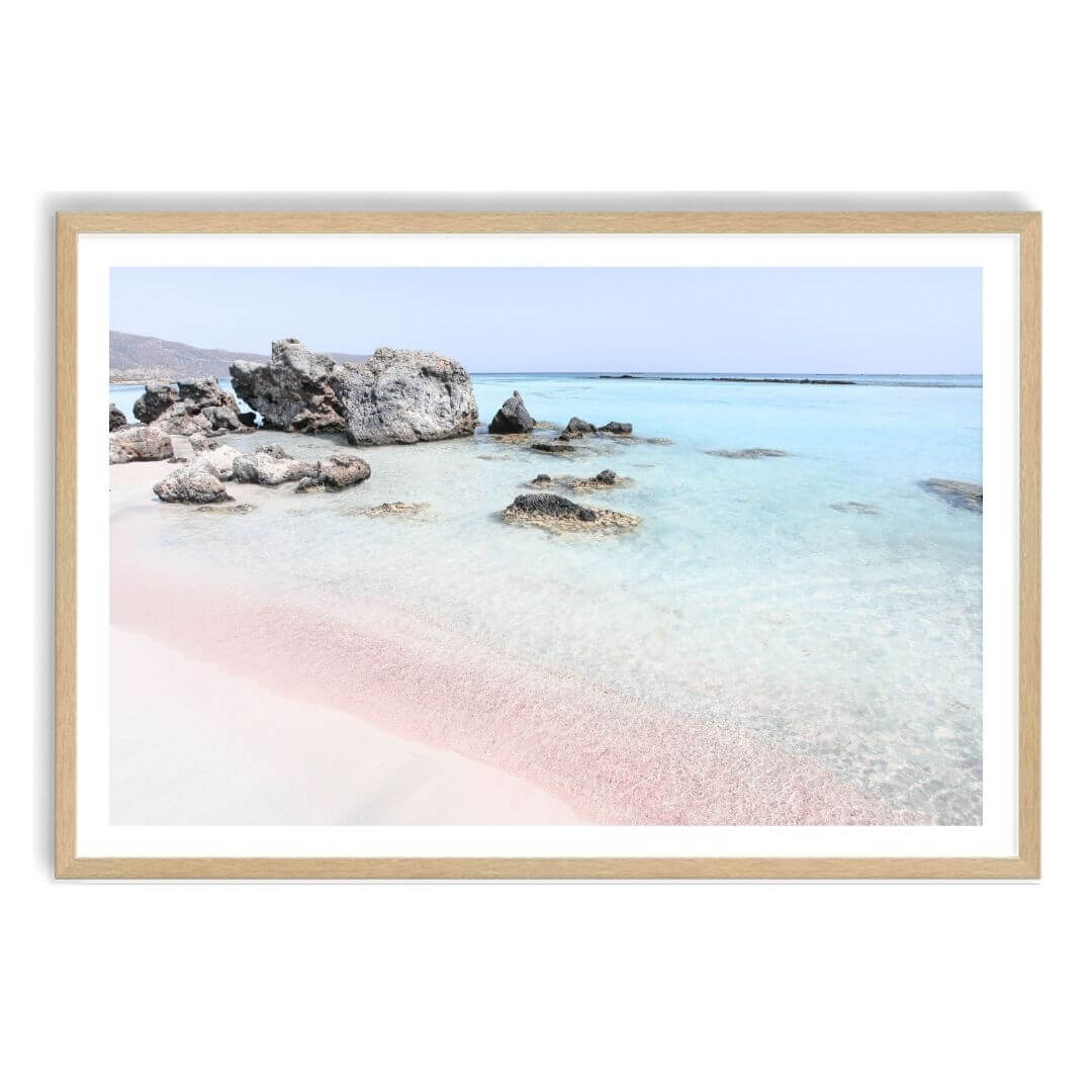 A wall art photo print of a pink beach in Greece with a timber frame, white border by Beautiful Home Decor