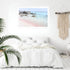 A wall art photo print of a pink beach in Greece with a white frame to decorate your bedroom walls