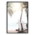 A photo wall art print of two white surf boards under the palm trees on a surfer beach in Hawaii in a black frame.