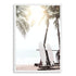 A photo wall art print of two white surf boards under the palm trees on a surfer beach in Hawaii in a white frame.