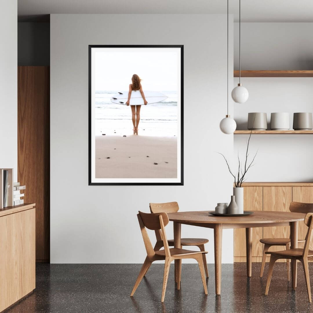 A wall art photo print of the girl with the surfboard with a black frame to style a coastal Australian dining room