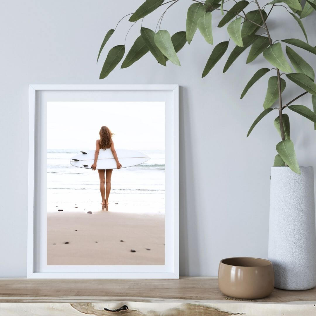 A wall art photo print of the girl with the surfboard with a white frame or unframed to style shelves and empty walls